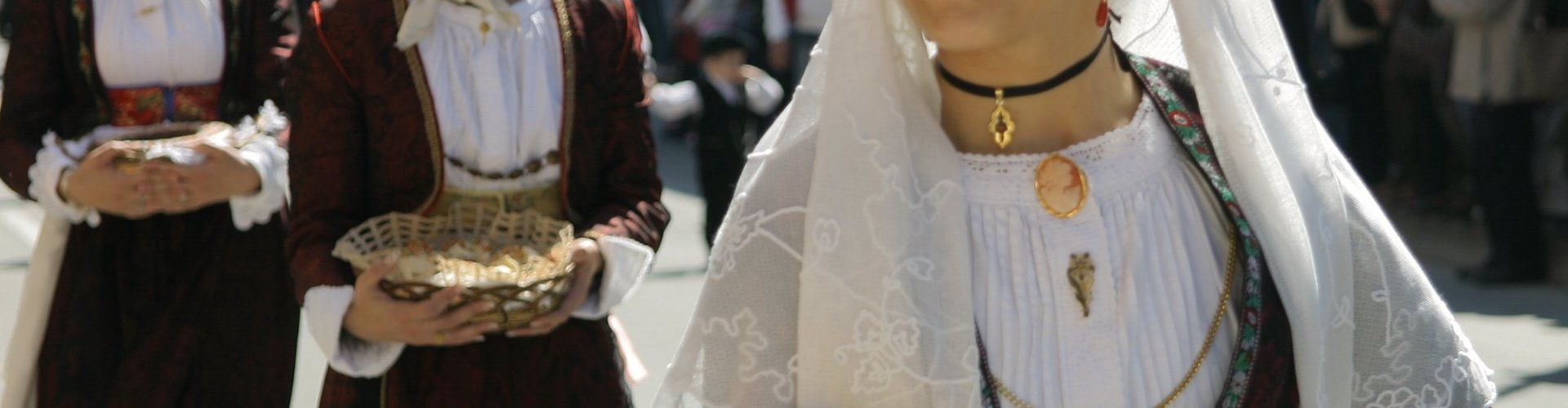 Donne in costumi sardi durante una processione