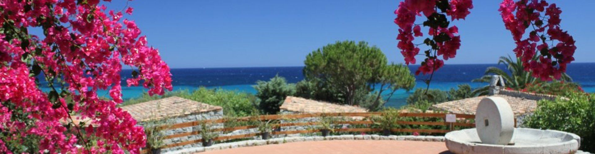 Piazzetta con Bougainville, mulino in granito e vista mare di Sant Elmo