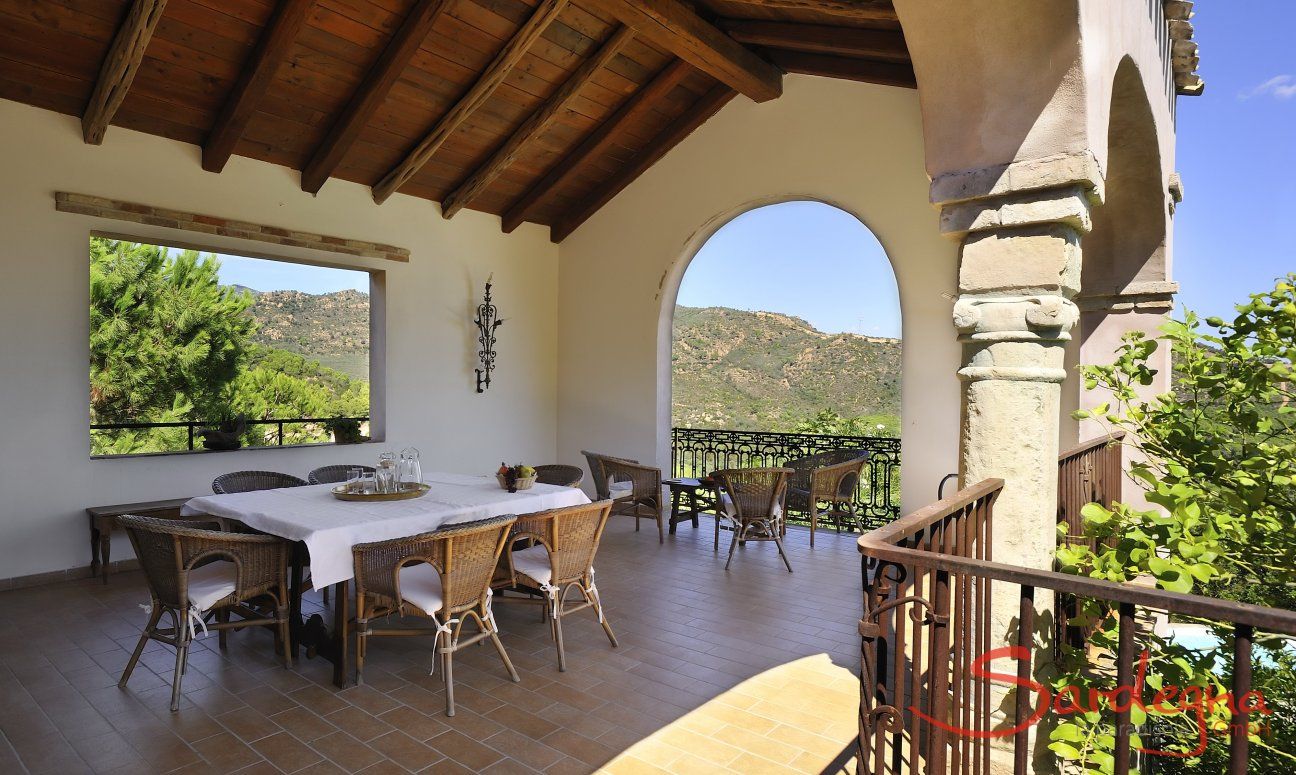 Terrazza coperta con tavolo per 8 persone e vista sul verde 