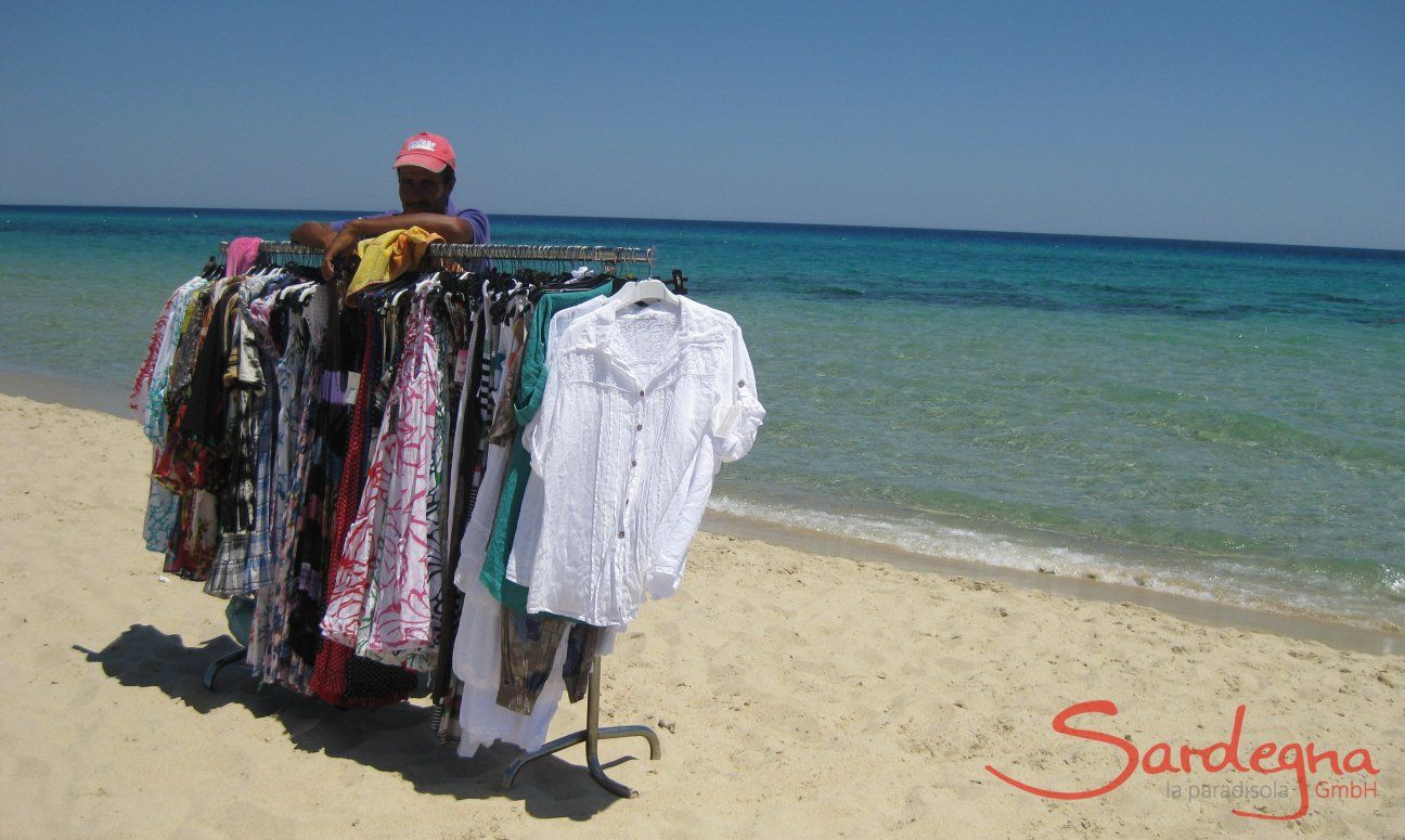 Venditore abulante con asta di vestiti sulla spiaggia di Costa Rei