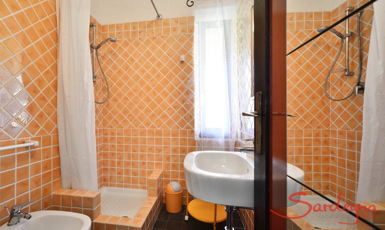 Bagno con piastrelle arancione con doccia di  Villa Serena, Costa Rei