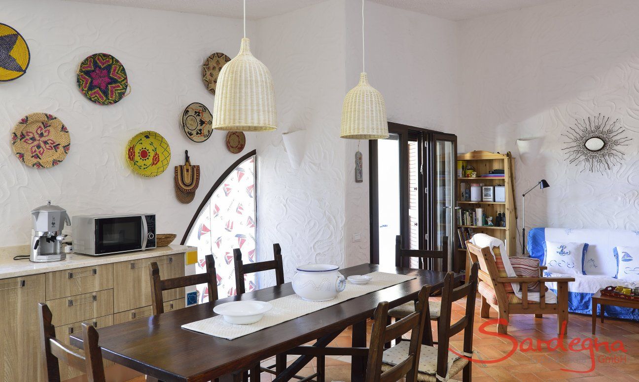 Villa Gaia | Sala con tavolo da mangiare e il muro decorato con cestini sardi salotto