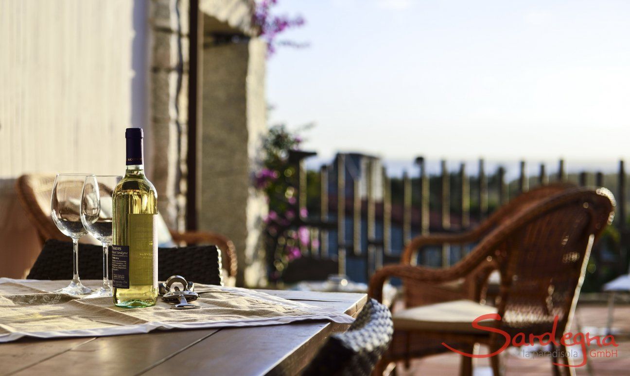 Li Conchi 7 | Aperitivo in veranda Bottiglia di vino bianco con due bicchieri sulla veranda di Li Conchi 7 con vista mare