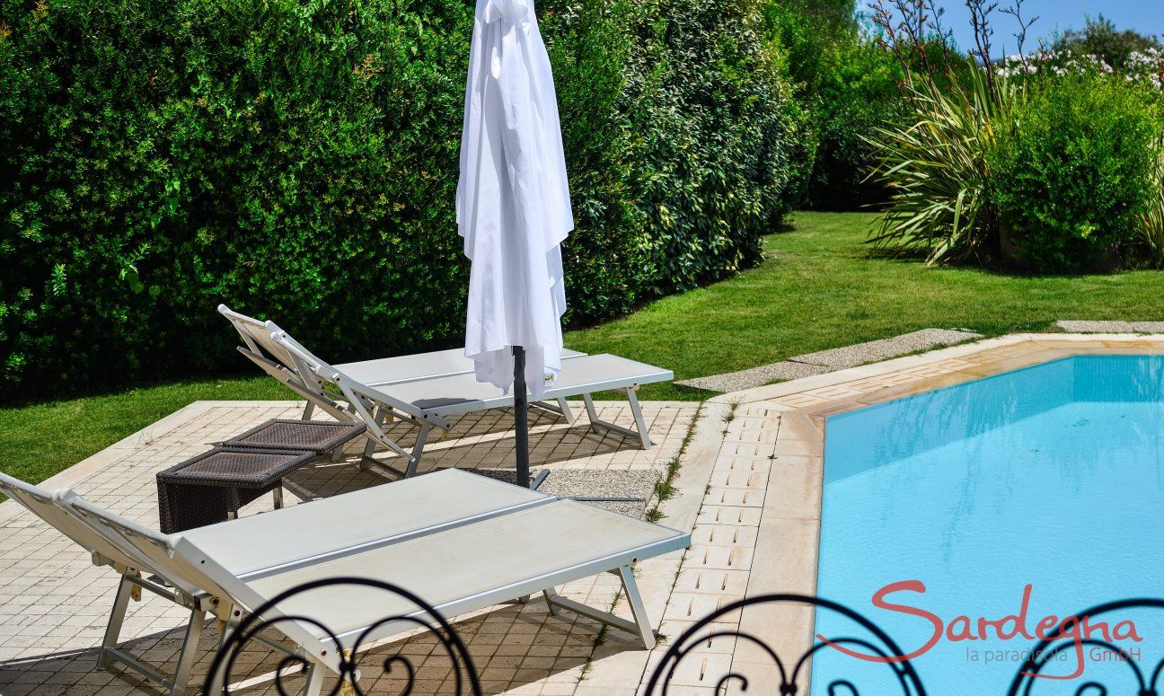 Villa del Campo | Lettini e ombrellone alla piscina con viste nel bel giardino verde Pool con lettini da sole