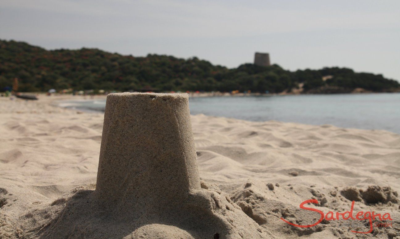 Modello della torre spagnola di Cala Pira fatto con la sabbia in primo piano, sullo sfondo la torre vera