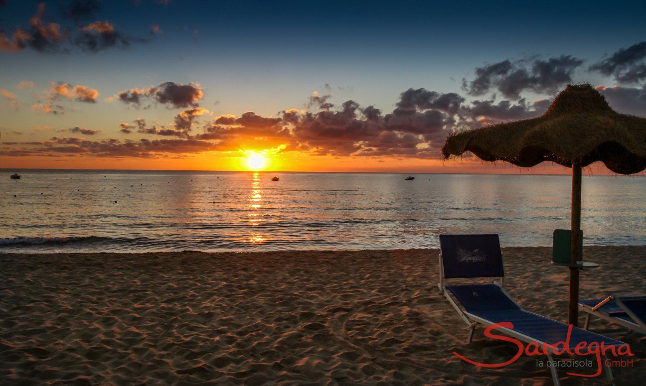 Il sorgere del sole sul mare di Cala Sinzias tinge il cielo di arancione