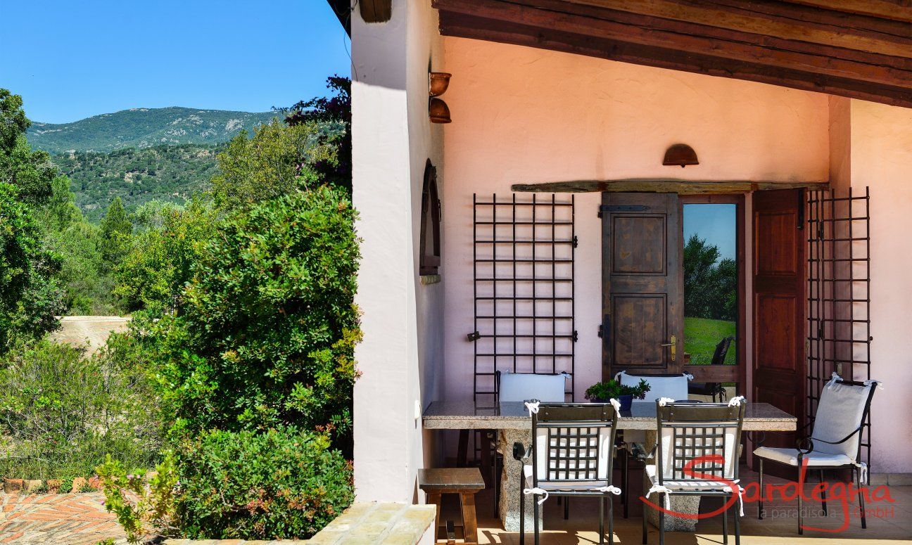 Villa Fiori 3 | Veranda ombreggiata con tavolo in granito e vista nel verde d'intorno Veranda ombreggiata con tavolo in granito e vista nel verde d'intorno