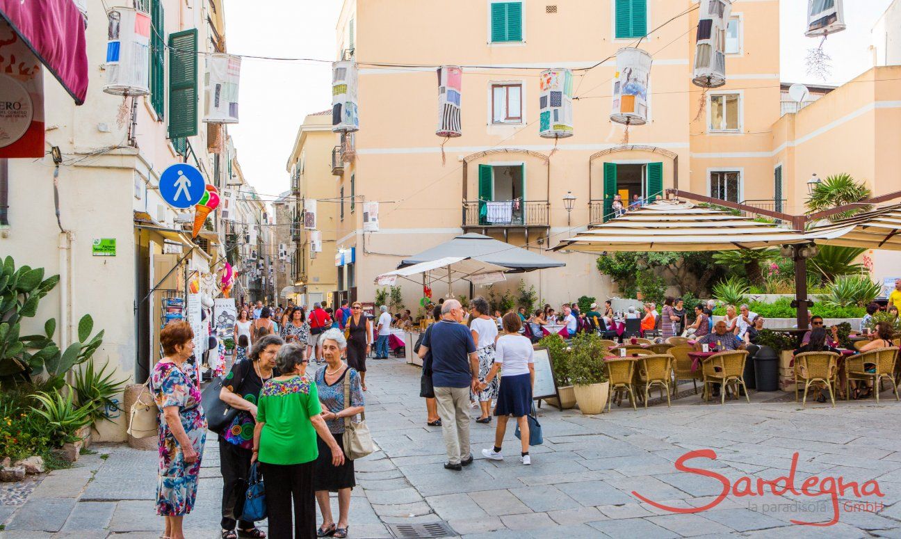 Le stradine e piazze pedonali di Alghero con gente che si incontra e fa shopping