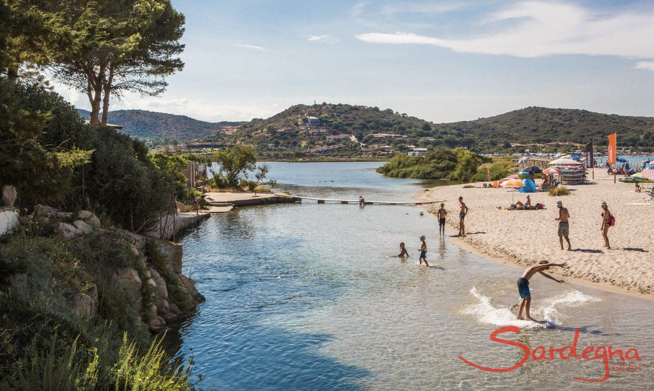 Bambini giocano nell'acqua bassa della laguna di Porto Taverna