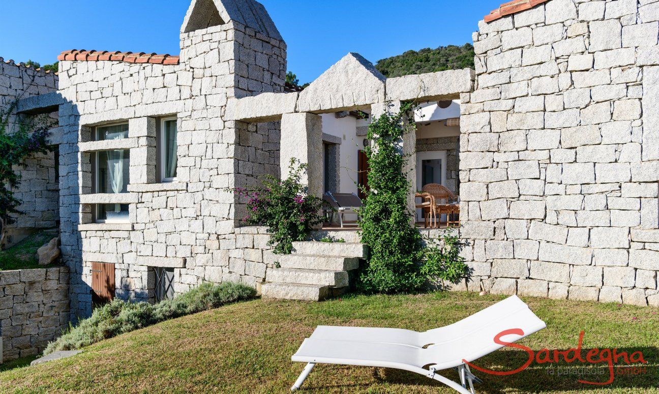 Facciata in granito della casa con scala che porta sulla veranda