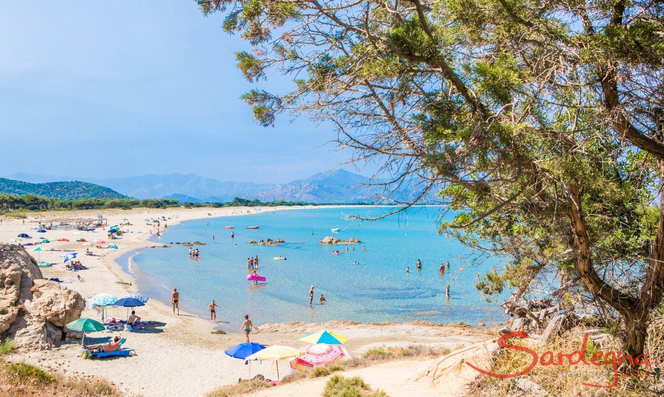 Spiaggia di Feraxi con alcuni ombrelloni e turisti in alta stagione