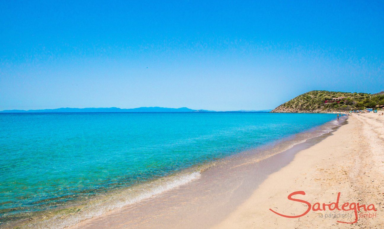 Acqua cristallina e sabbia bianca della spiaggia di Geremeas con la costa di Cagliari sul fondo