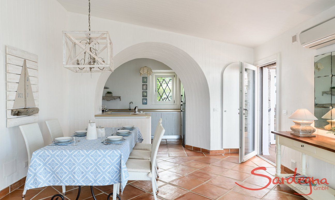 Li Conchi 30 | Tavolo da pranzo e scorcio della cucina e della porta d'ingresso Presentazione Li Conchi 30