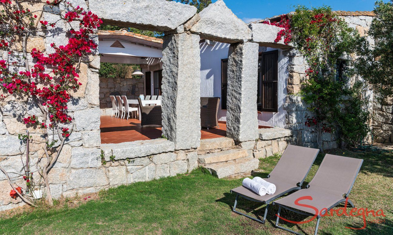 Casa 17 | Giardino con lettini da sole e archi in granito della terrazza Casa 17, Sant Elmo, Sud Sardegna