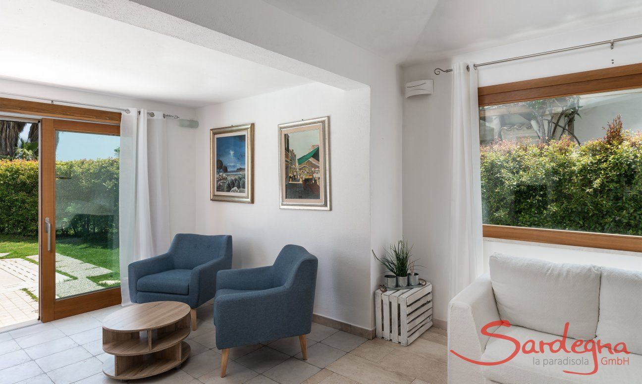Villa del Campo | Salotto con mobili per rilassarsi e grande finestre con vista nel verde giardino Villa del Campo, Is Molas, Pula