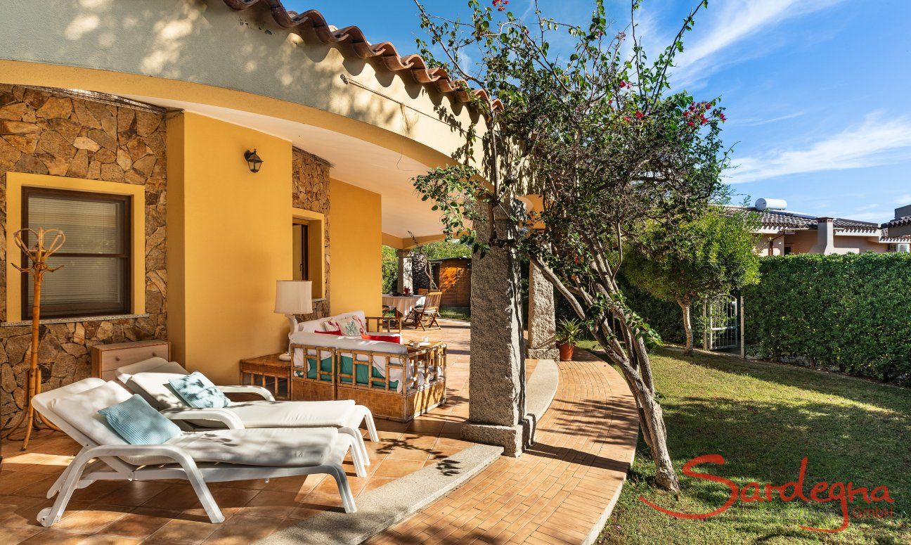 Villa Tiziana 11 | La terrazza coperta arredata con lettini da sole, un salotto esterno e un tavolo per mangiare Rittratto della casa