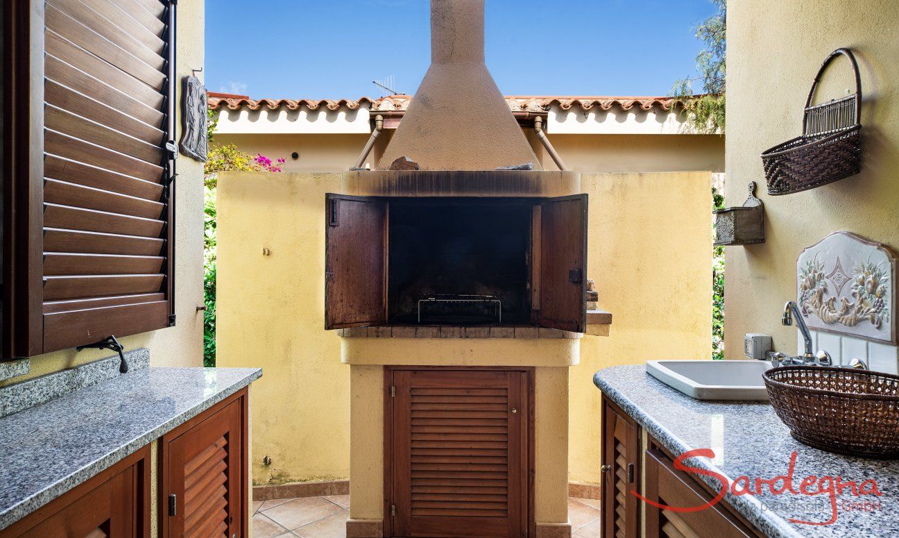 Villa Tiziana 11 | Il barbecue in muratura si trova vicino alla casa e ad un banco di lavoro con lavandino Rittratto della casa