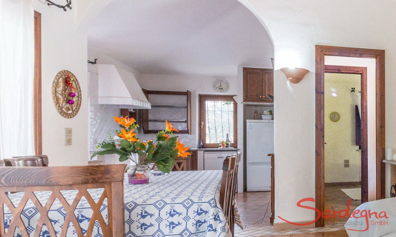 Villa Maestrale | Tavolo da pranzo, cucina e ingresso alla camera Villa Maestrale, Cala Ginepro, Olbia