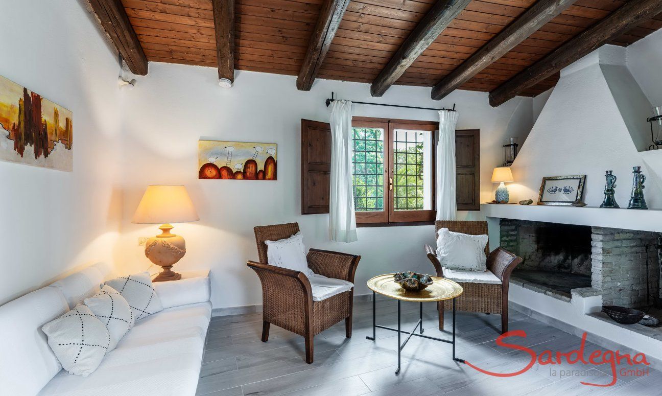 Villa Fiori 3 | Il soggiorno è arredato in modo accogliente con un divano in muratura e un caminetto interno. New Picture 2025