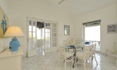Villa Bella | Sala da pranzo con ventilatore e accesso alle verande Zona per pranzare con porte verso la terrazza