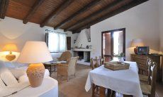 Villa Fiori 3 | Salone con camino, divano in muratura, TV e tavolo da pranzo per 6 persone V. Fiori 3