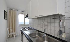 Apartment Azzurra | Cucina con forno elettrico, fornelli a gas, lavandino e vista mare Cucina