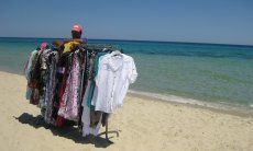 Venditore abulante con asta di vestiti sulla spiaggia di Costa Rei