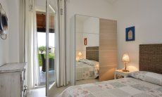 Camera con letto, armadio e porta finestra sul giardino  Villa Campidano 21