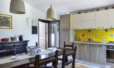 Villa Gaia | Cucina abitabile con tavolo rustico e porta al giardino cucina