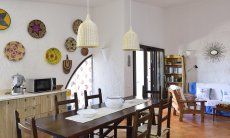 Villa Gaia | Sala con tavolo da mangiare e il muro decorato con cestini sardi salotto