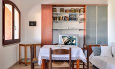 Villa Le Ginestre 2 | Sala al primo piano con tavolo, divano e libreria Sala al primo piano con tavolo, divano e libreria