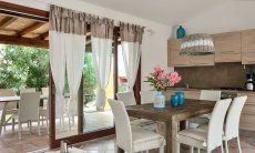 Villa Campidano 8 | Zona pranzo con cucina, tavolo e vista sul giardino Sala pranzo con cucina
