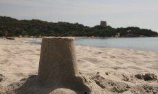 Modello della torre spagnola di Cala Pira fatto con la sabbia in primo piano, sullo sfondo la torre vera