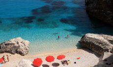 Tre ombrelloni rossi sulla spiaggia paradisiaca di Cala Goloritze