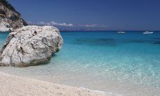 Roccia grande, tonda e bianca nel mare limpido davanti alla spiaggia di Cala Goloritze