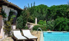 Villa Fiori 3 | Pisicna limpida con lettini da sole in legno e scorcio della casa e alberi verdi Pisicna limpida con lettini da sole in legno e scorcio della casa e alberi verdi