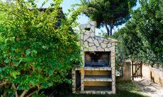 Casa Meloni 2 | Grande barbecue murato nel giardino Barbecue in muratura nel giardino di Meloni 2 a Sant Elmo