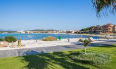 Spiaggi di città con prato verde e sabbia bianca nel porto di Gofo Aranci