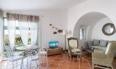 Li Conchi 30 | Area relax della sala con finestra panoramica, tavolo rotondo, TV e divano Presentazione Li Conchi 30