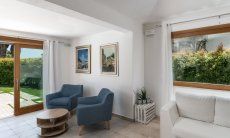 Villa del Campo | Salotto con mobili per rilassarsi e grande finestre con vista nel verde giardino Villa del Campo, Is Molas, Pula