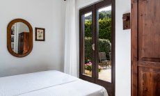 Villa Palme | Camera 3 con letto matrimoniale e porta sulla veranda Camera Villa Palme Costa Rei