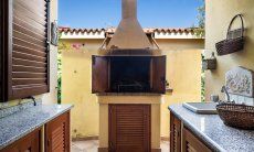 Villa Tiziana 11 | Il barbecue in muratura si trova vicino alla casa e ad un banco di lavoro con lavandino Rittratto della casa