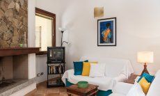 Villa Gioconda 21 | Angolo relax con divani, TV e camino Interno della casa