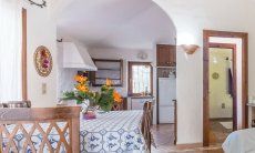 Villa Maestrale | Tavolo da pranzo, cucina e ingresso alla camera Villa Maestrale, Cala Ginepro, Olbia