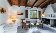 Villa Fiori 3 | Il soggiorno è arredato in modo accogliente con un divano in muratura e un caminetto interno. New Picture 2025