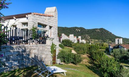 Casa in granito e giardino con lettini da sole