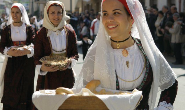 Donne in costumi sardi durante una processione